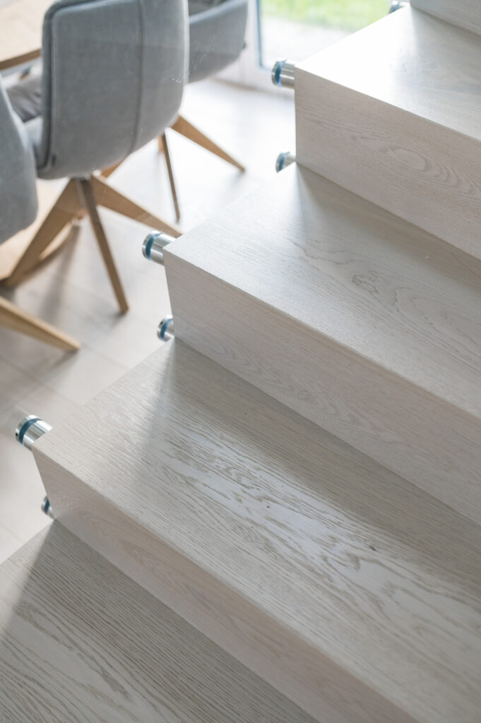 Schody dębowe bielone ze szklaną balustradą
